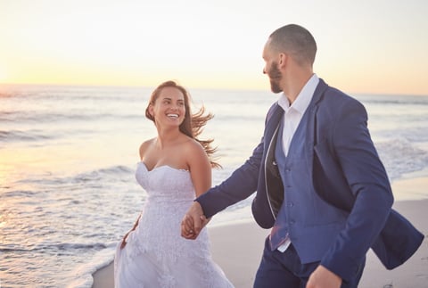 Couple, wedding and beach smile in sunset on romantic walk together after getting married