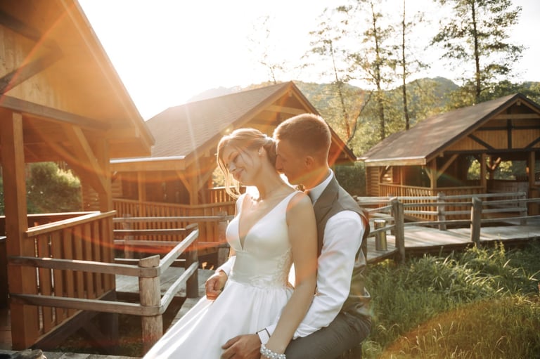 Bride and groom sitting on a bridge in front of a mountain lodge in Arkansas