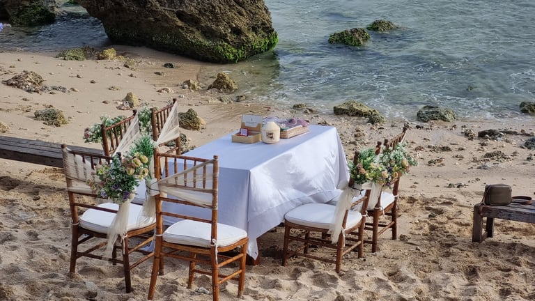Beach wedding setup with tables decorated for ceremony at sunset